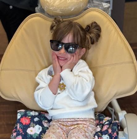 Child wearing sunglasses in dental chair