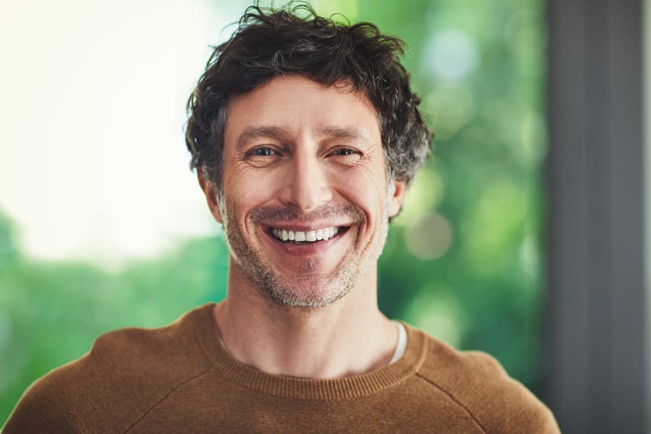 Man smiling while looking at the camera.